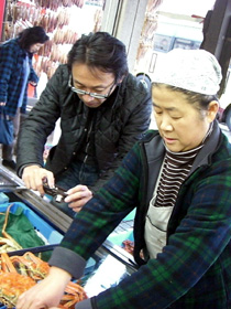 おばちゃんの話に耳を傾ける勝屋さん